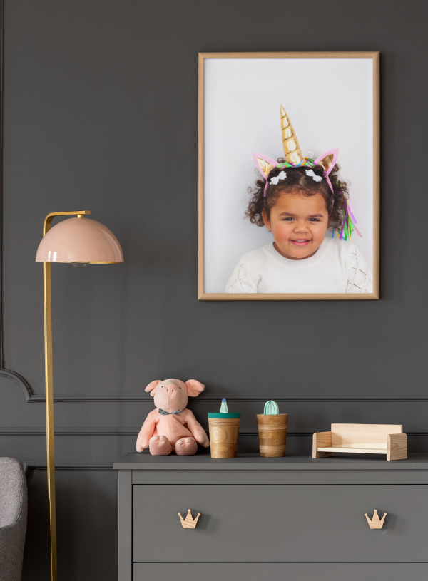 art print with portrait of a preschool girl featuring a dark room with matching pink furniture
